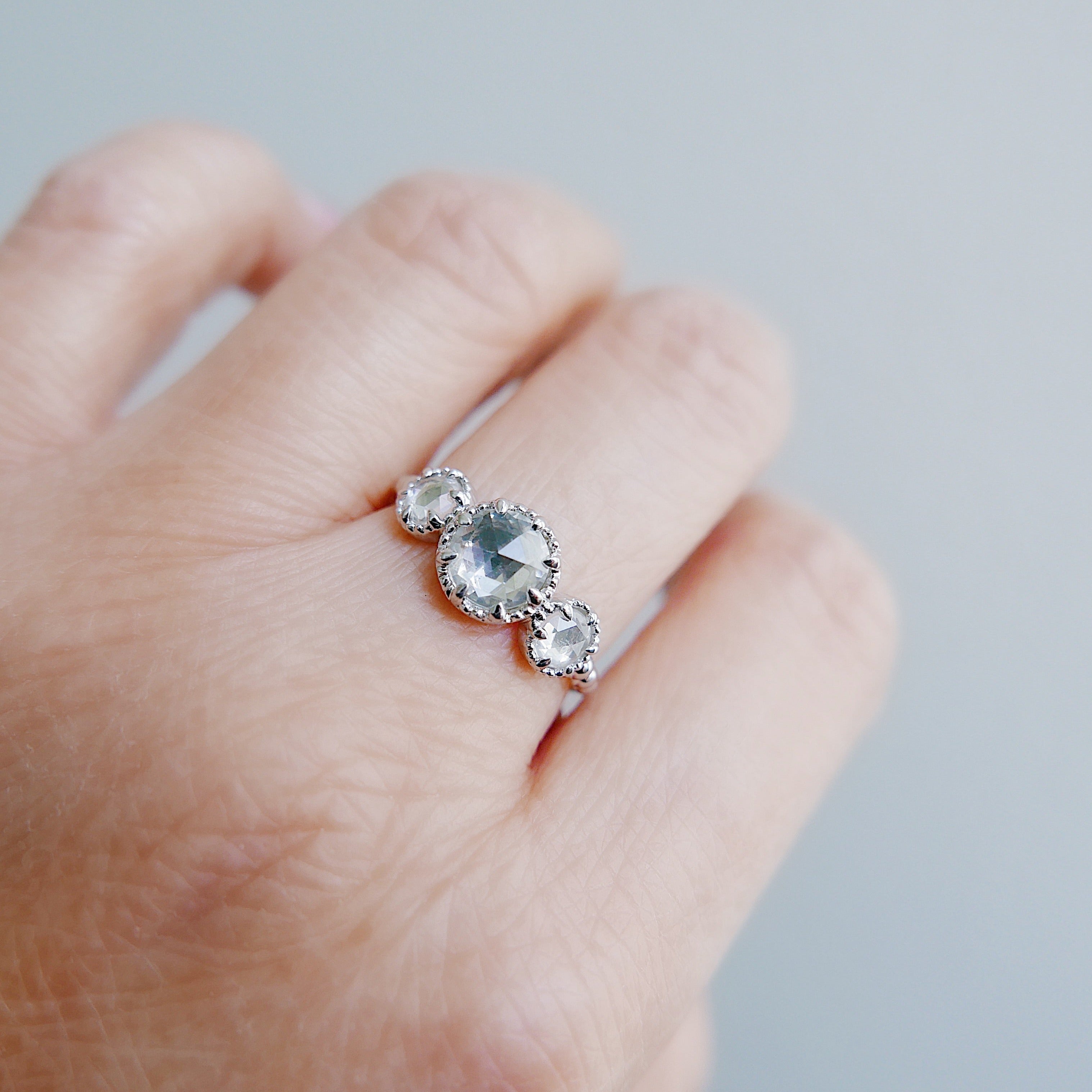 Three stone rosecut ring worn on middle finger.